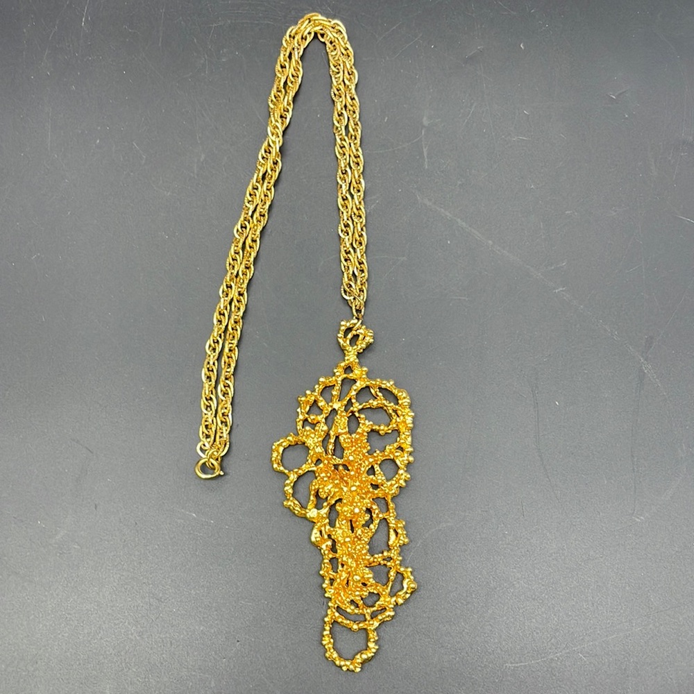 Gold tone necklace with abstract pendant